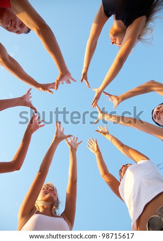 hands of young people stretching to the center