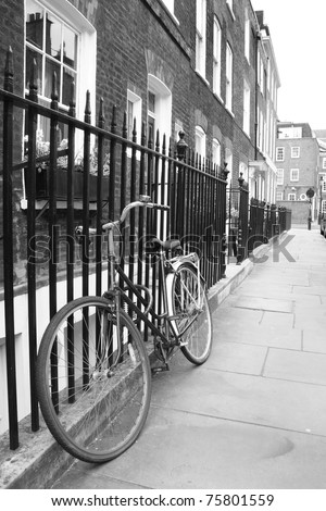 Bicycle leaning against railings in a London street