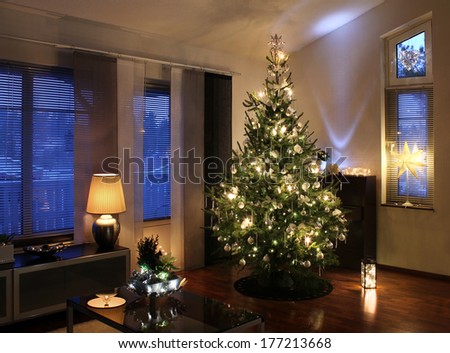Illuminated Christmas tree decorated in modern living room