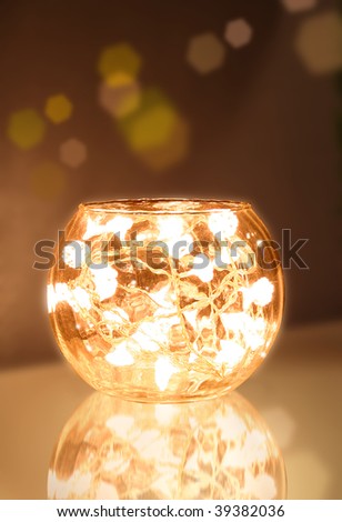 Glass bowl filled with christmas light chain sending warm light
