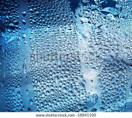 Refreshing water drops on blue transparent surface