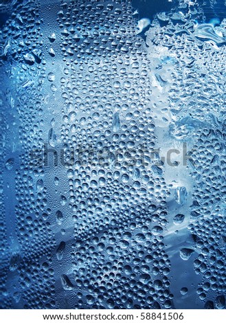 Refreshing water drops on blue transparent surface