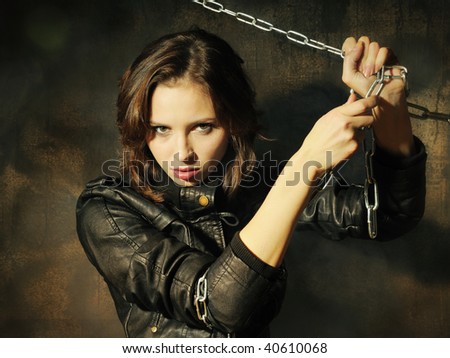 Young girl in leather jacket with chain in hands