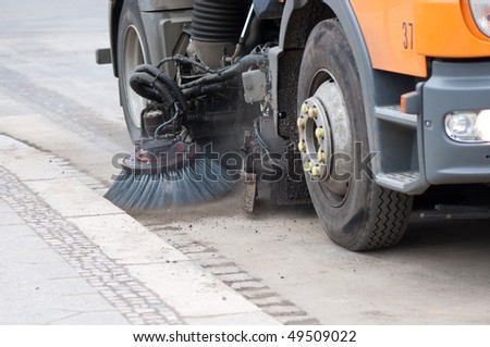 A sweeping machine cleans the street