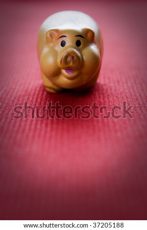Small clay pig on a red fabric