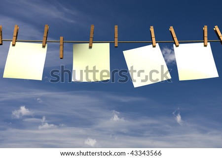 Four blank pieces of paper hanging on a clothesline