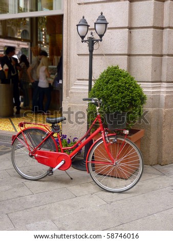 Red bicycle outside shop in Milan, Italy
