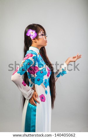 Beautiful asian woman wears a national dress isolated on a grey background