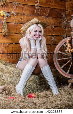 Young sexy girl in underwear and white boots sit in the barn with hay