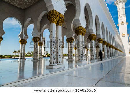 ABU DHABI, UAE - JUNE 11: The Sheikh Zayed Grand Mosque, muslims and tourists on June 11, 2013 in Abu Dhabi, UAE. It is the largest mosque in UAE and eighth largest mosque in world