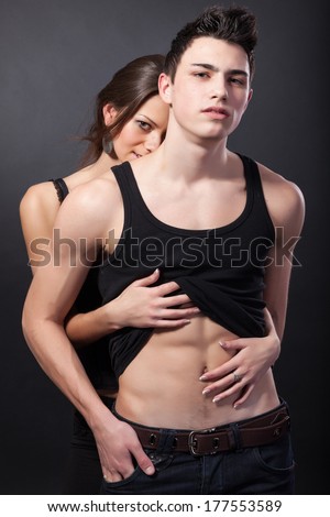 Happy young couple hugging. First love on dark background