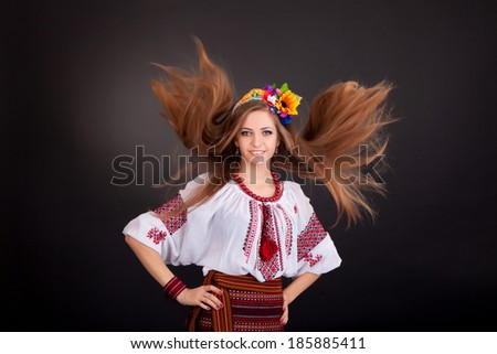 Attractive woman wears Ukrainian national dress isolated on a white background. Portrait of a beautiful girl with flying brown hair