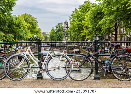 AMSTERDAM, NETHERLANDS - AUGUST 19: Bicycles on a bridge over the canals of Amsterdam. Amsterdam is the capital and most populous city of the Netherlands on August 19, 2014