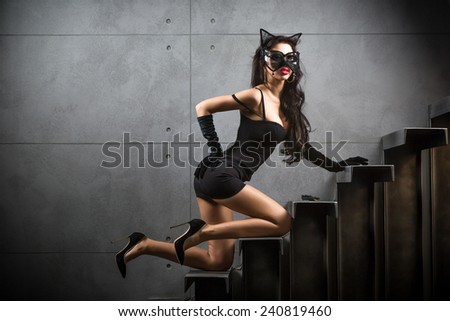 sexy woman in cat woman suit lying on stairs at backyard of building
