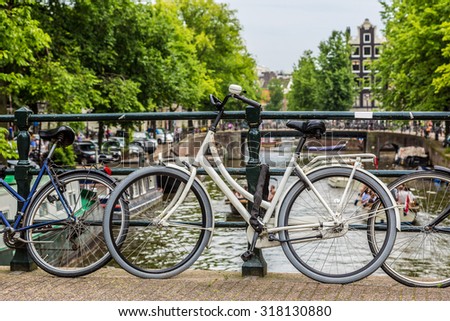 Bicycles on a bridge over the canals of Amsterdam, Netherlands in a summer day