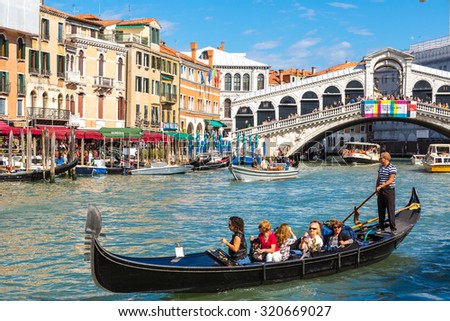 VENICE, ITALY - JUNE 18, 2014: Gondola at the Rialto bridge in Venice, in a beautiful summer day in Italy on June 18