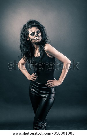 Young woman in day of the dead mask skull face art. Halloween face art