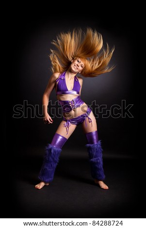 Young woman dancing with flowing hair on black background