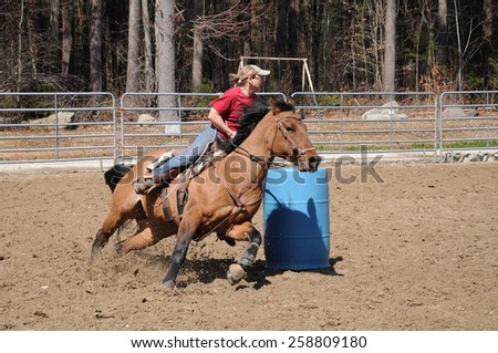 A young woman turns around a barrel and races to the finish line