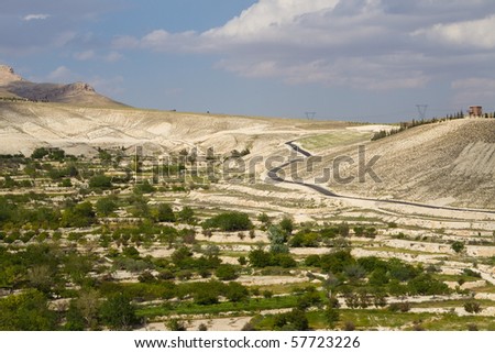 Windy road around Syrian hillside with a stormy cloud background