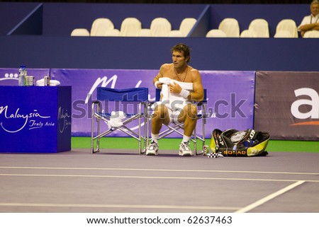 SHAH ALAM, MALAYSIA - OCTOBER 8: Australian Pat Cash teases the fans by removing his shirt at Showdown of Champions Tennis on October 8, 2010 in Shah Alam, Malaysia