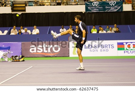 SHAH ALAM, MALAYSIA - OCTOBER 8: Croatian Ivanisevic kicks the ball back at Pat Cash in a fun match at Showdown of Champions Tennis on October 8, 2010 in Shah Alam, Malaysia