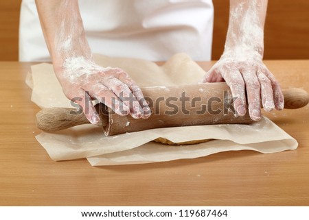 Making Pastry Dough for Hungarian Cake. Series. A baker rolling a dough between sheets of baking paper.