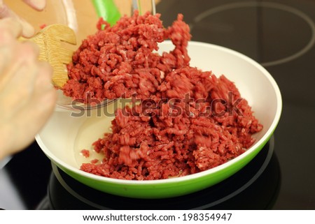 Adding ground beef into frying pan. Making enchilada tortilla with beef. Series.