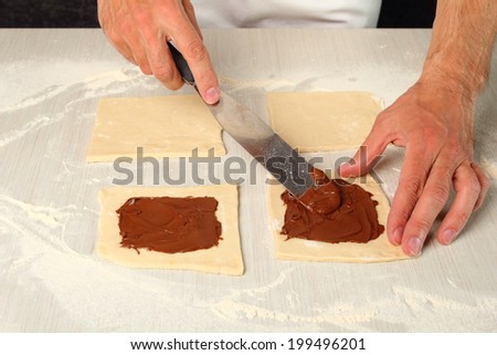 Spreading chocolate. Making Chocolate Croissants with Puff Pastry