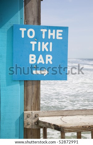 To the tiki bar sign with breaking waves in background.