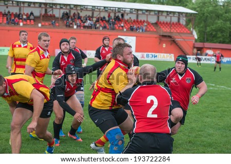 MOSCOW - MAY 13: Some players in a rugby tackle in the Russian Rugby Championship 2014 match between Slava CSP (yellow) and Metallurg (black), on May 13, 2014, in Moscow stadium Slava Russia.