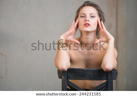 Sexy beautiful young woman sitting on a chair