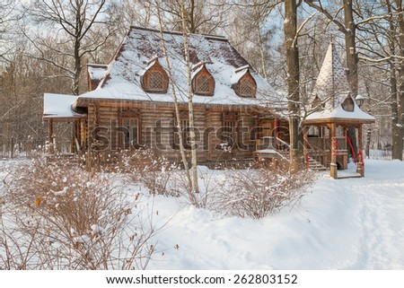 Wooden house in the old style in a snowy forest