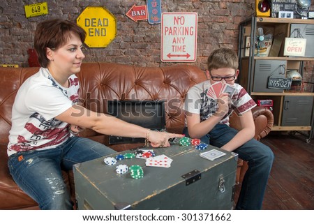 Happy mother and son playing in an entertaining game at home - leisure, games and lifestyle concept