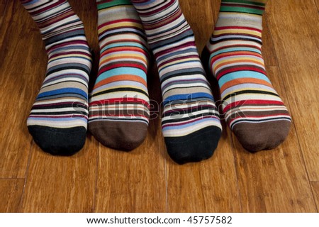 His and hers striped socks on wooden floor