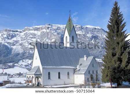 Swiss church in Flims Laax set against mountains and snow