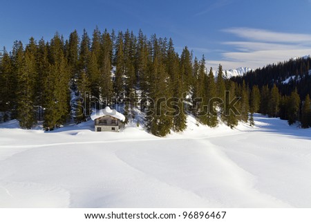 Log cabin in snow in the Alps