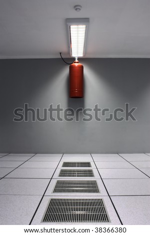 A dreamy shot of a server/data center with air-conditioner grids and a fire suppression system including ozone friendly gas bottle and a smoke detector.