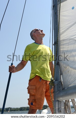 Man on a yacht looks upwards