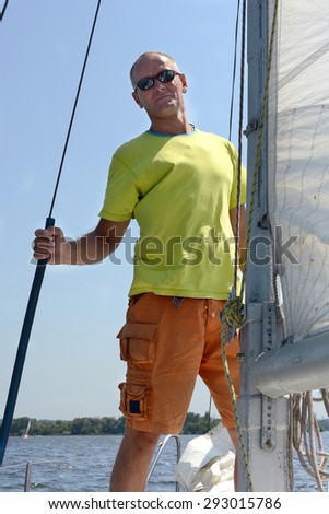 Man on a yacht looks to the camera
