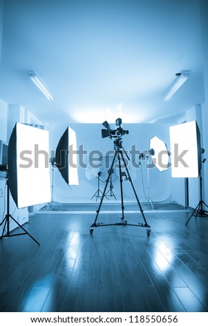 Photo of an empty photographic and video studio with modern lighting equipment. Color processed