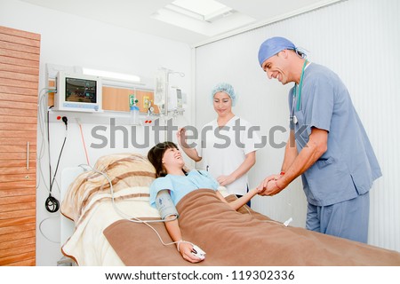 Doctor comforting female patient and nurse in a hospital