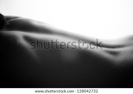 Back of healthy athletic caucasian muscular young man. Black-white photo.