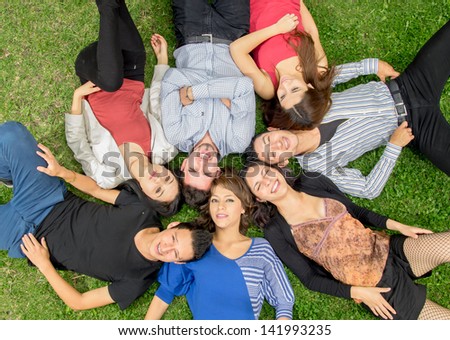 Group of hispanic friends laying down in park