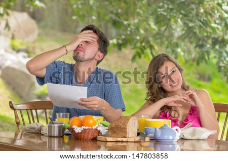 Stressed man and woman arguing about family budget