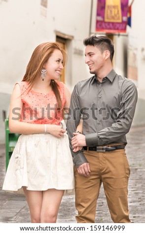 Young couple in a candid shot. They are walking in the streets of Quito, Ecuador