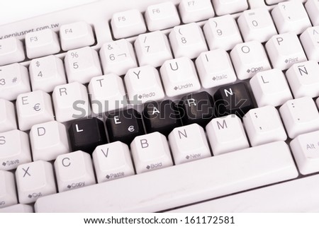 Word Learn written with black keys on computer keyboard.