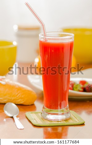 breakfast and glass of red juice on wooden table