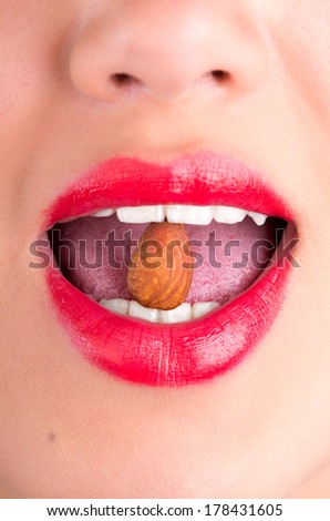 Close up of female mouth eating almond