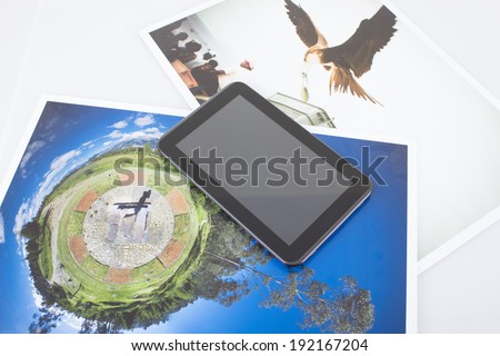 tablet device on top of pictures, mobile technology concept